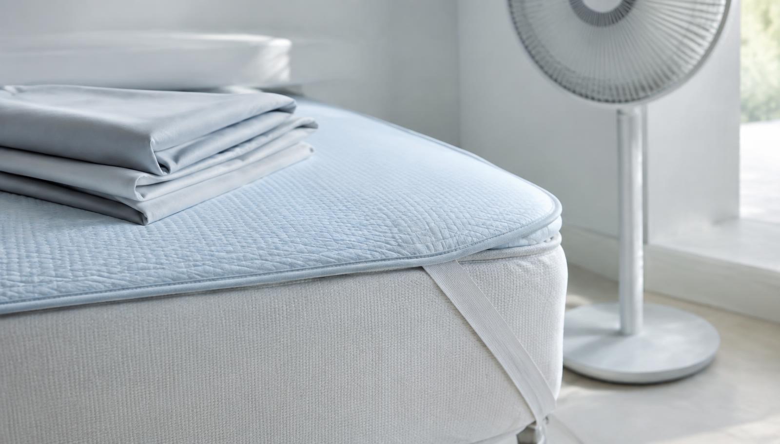 Cooling mattress pad, folded sheets and a pedestal fan